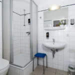 Badezimmer mit Dusche und WC im Doppel- oder Zweibettzimmer mit Balkon