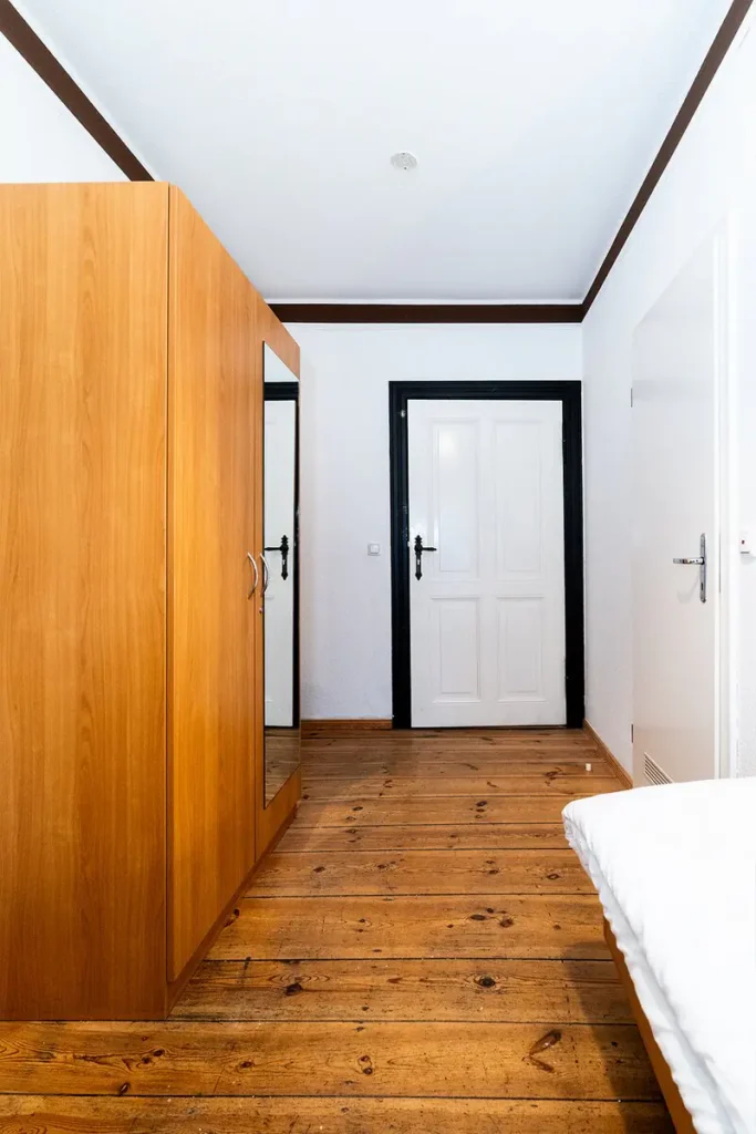 Doppel- oder Zweibettzimmer mit Balkon in Kleinmachnow mit Doppelbett, Sitzbereich und Holzboden