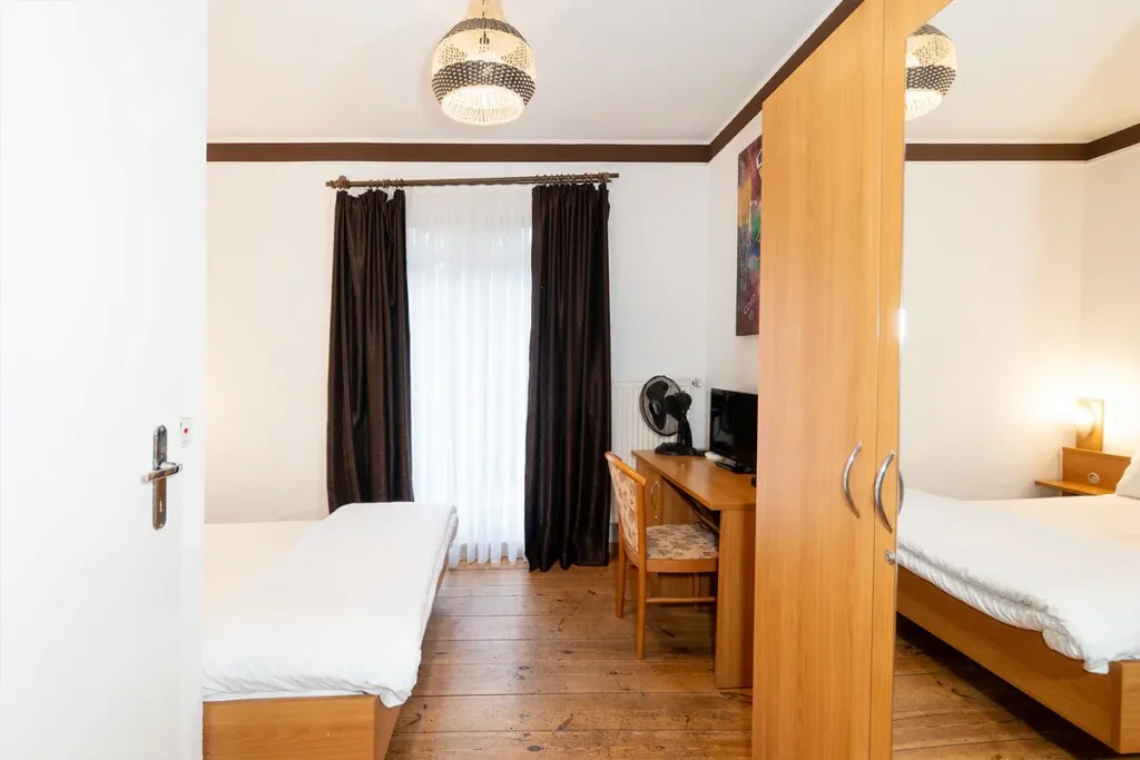 Sitzbereich mit Schreibtisch und Flachbild-TV im Doppel- oder Zweibettzimmer mit Balkon