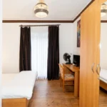 Sitzbereich mit Schreibtisch und Flachbild-TV im Doppel- oder Zweibettzimmer mit Balkon