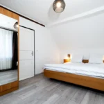 Kleiderschrank im Doppel- oder Zweibettzimmer mit Balkon und Holzfußboden