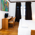 Zweibettzimmer mit Sitzbereich und Schreibtisch in der Pension zur Schleuse Kleinmachnow