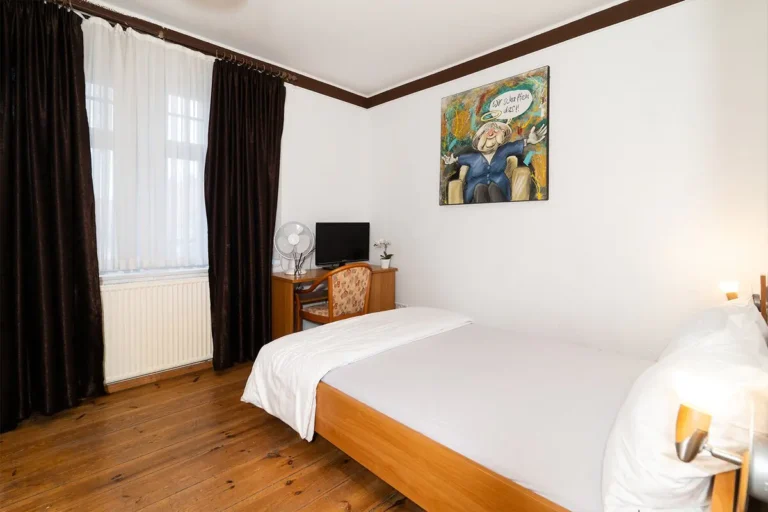 Helles Gästezimmer mit TV und Fenster